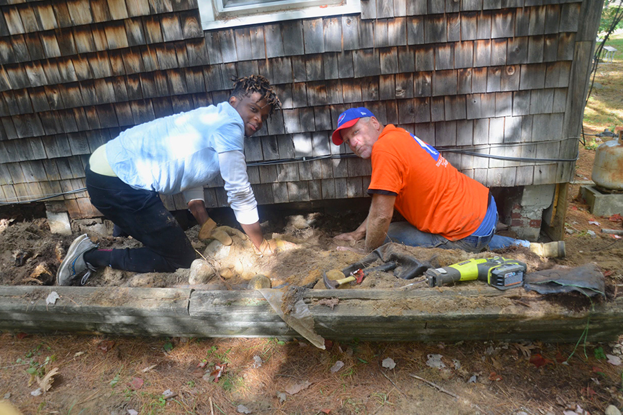 Fuller Housing volunteer Butch and SJC volunteer Diamond Doe dig out before adding insulation to the skirting to winterize the McFarland’s home.