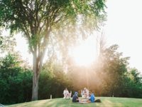 students sit on lawn with aura of sun