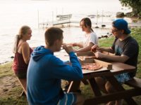 students at picnic table at lake