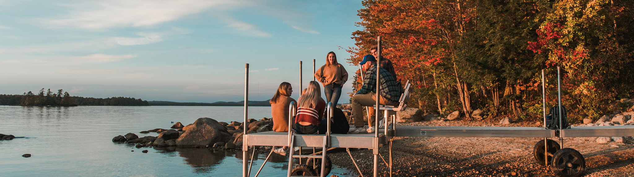 students on dock at lake in fall