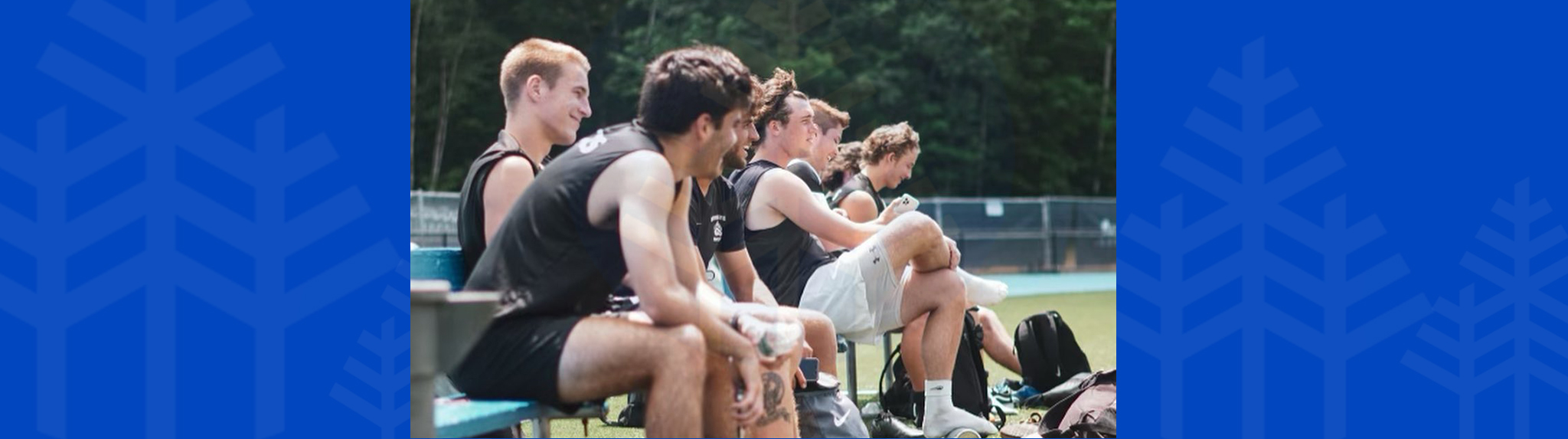 men's soccer team sit on bench