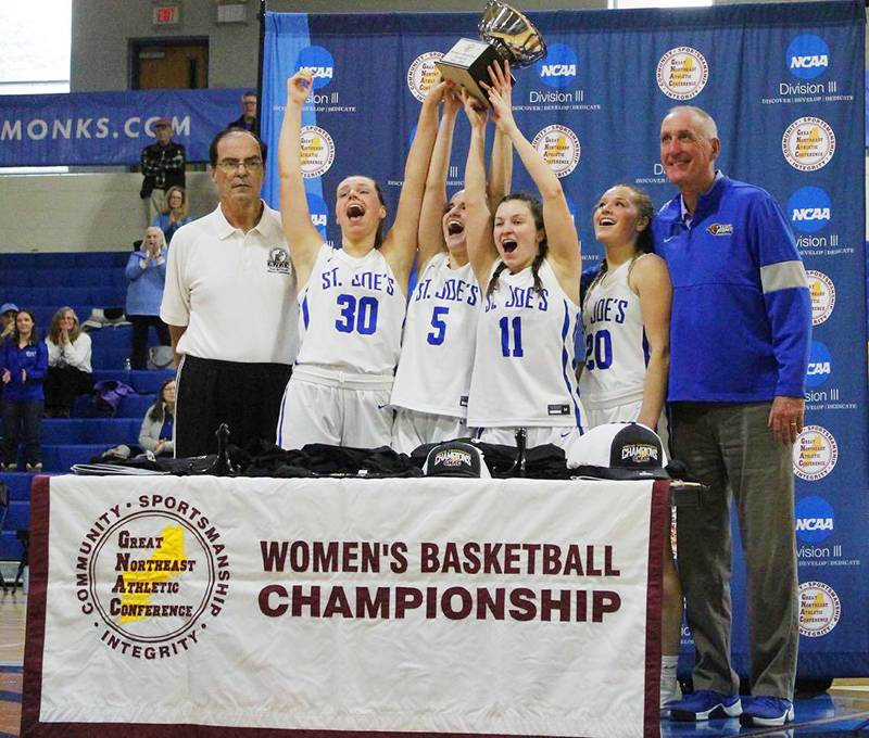 Women's basketball players raise the trophy
