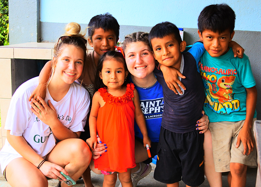 SJC students pose with some of the local children in Guatemala.